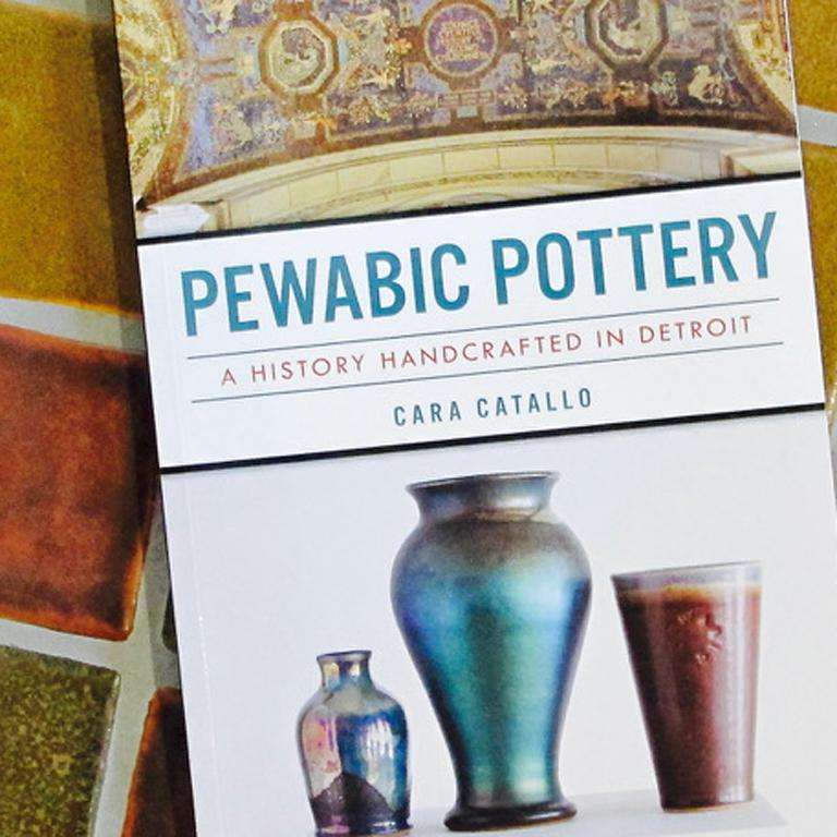 The Pewabic Pottery Book's cover features images of three ceramic vessels at the bottom and a historic Pewabic mural found at the Detroit Public Library at the top.