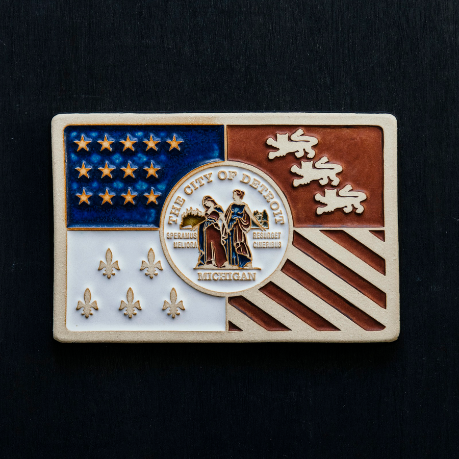 Hand-painted Detroit Flag tile stands out against a dark, black-stained wooden background.