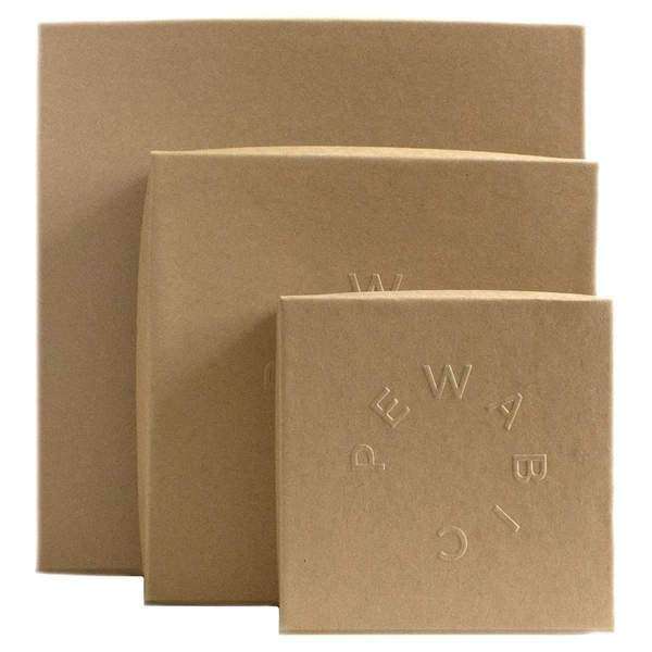 Three brown craft paper boxes are stacked together. Each has the word Pewabic embossed into the lid.