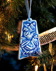 The ornament is glazed in a steel blue color with a pale blue ribbon.