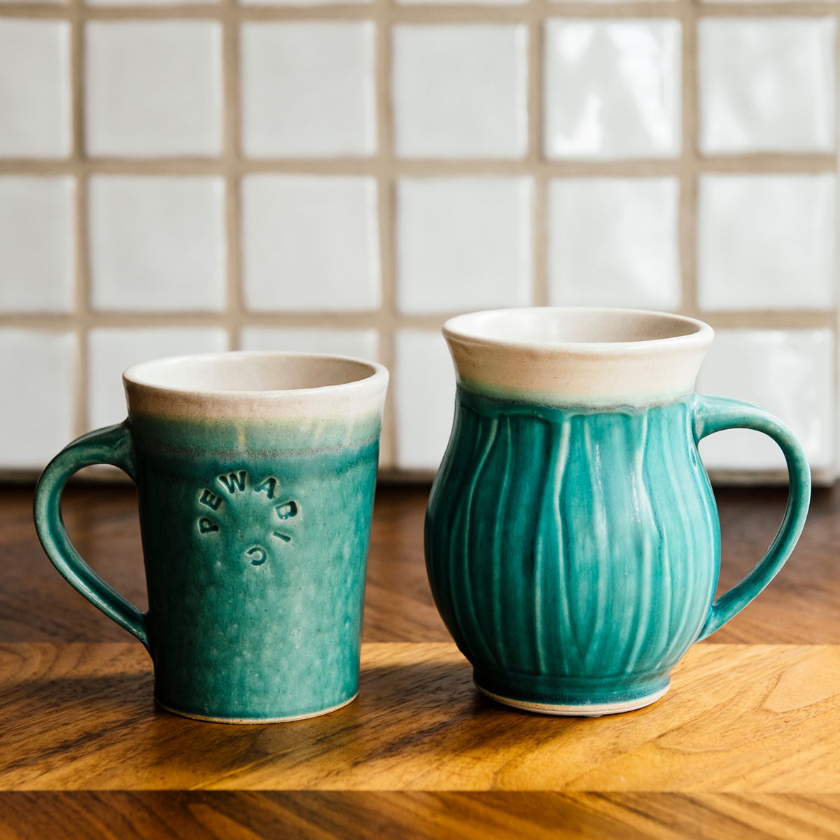 A photo comparing the Cafe Mug and the Classic mug shows that the classic mug is slightly taller than its straight-sided Cafe counterpart.