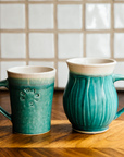 A photo comparing the Cafe Mug and the Classic mug shows that the classic mug is slightly taller than its straight-sided Cafe counterpart.