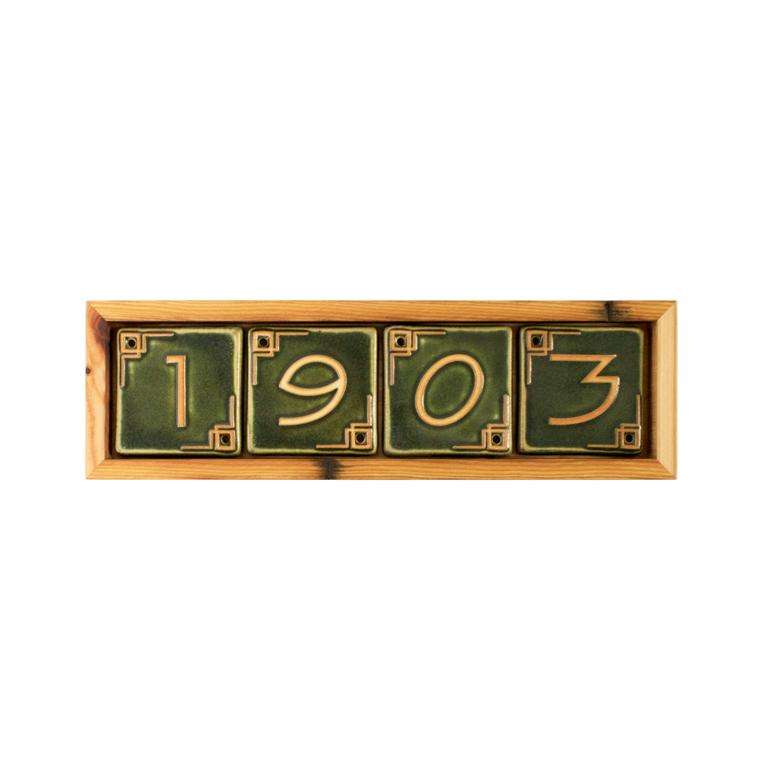 The light blonde wooden address frame holds Leaf green numbers that form the year Pewabic was founded: 1903.