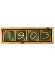 The light blonde wooden address frame holds Leaf green numbers that form the year Pewabic was founded: 1903.