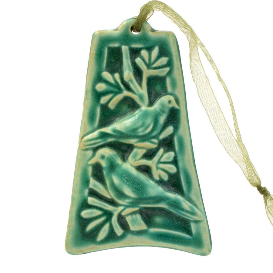 The ornament is glazed in a matte turquoise green color with a pale green ribbon..