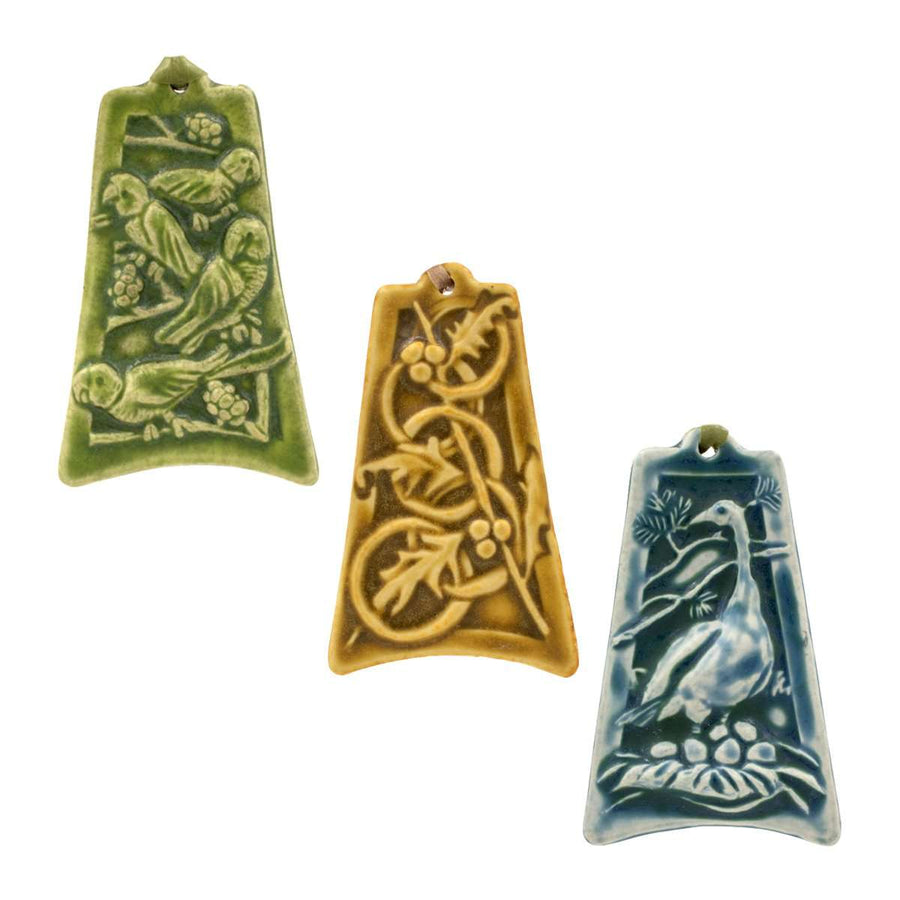 Three colorfully embossed ornaments are against a white background: one has four parrots resting tree branches covered with berries, another has five intertwined rings with holly and berries strewn around them, the last has a goose keeping watch over her nest filled with six eggs.