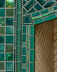 Detail shot of the fireplace that includes Iridescent and varying blue/green field tiles along with custom-cut tiles crafted specifically for this installation.