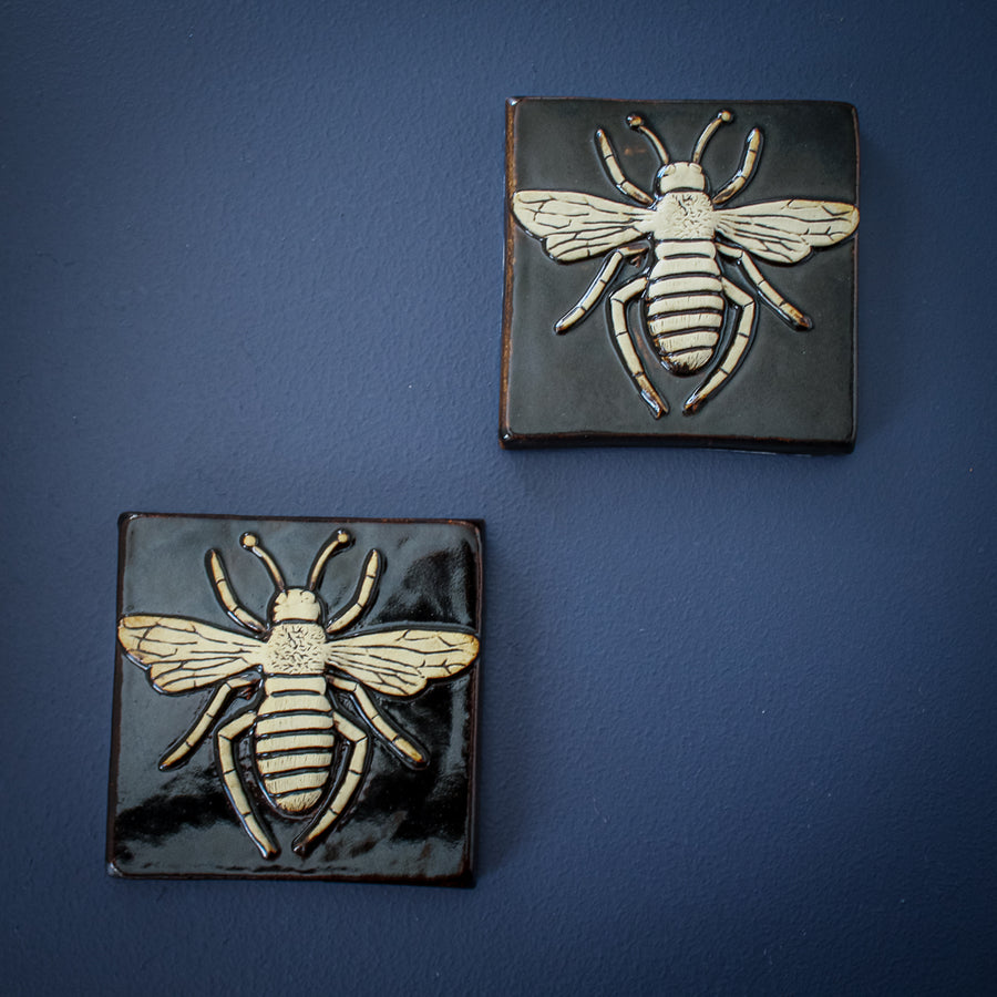 The bee is scraped to show the cream colored clay while the background has a glossy black glaze.