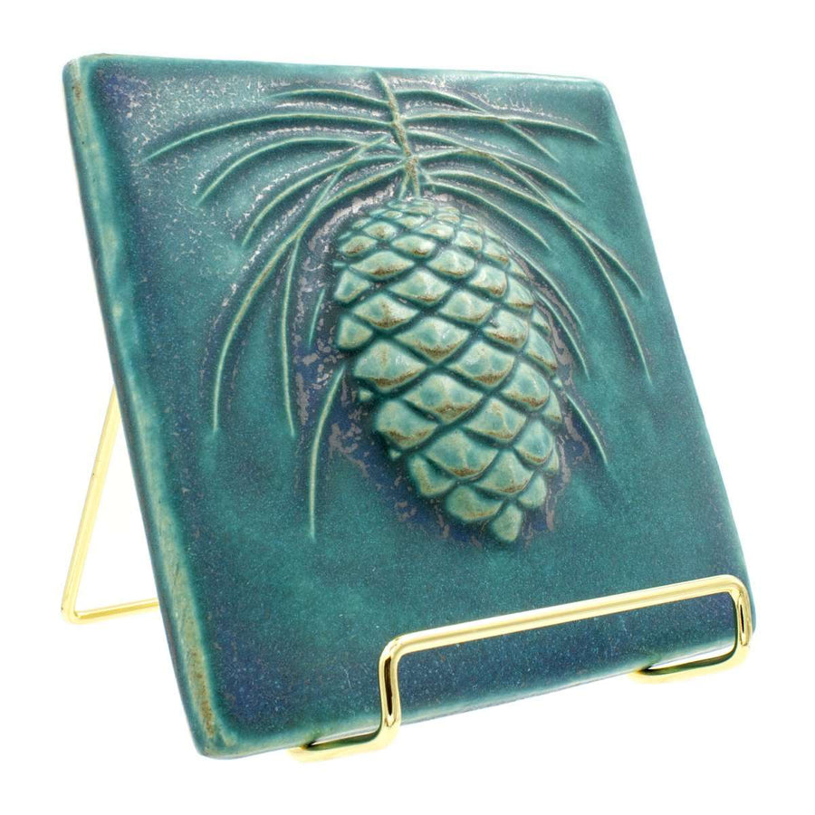 6x6 Pinecone tile rests in a 4" gold wire frame stand.