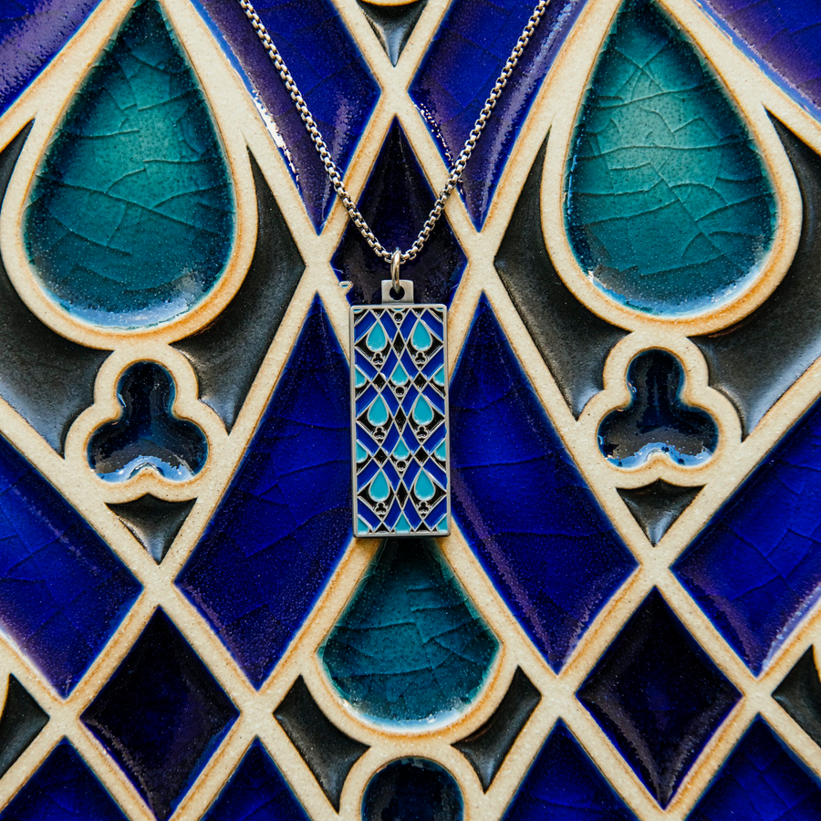 The necklace rests on the Women's City Club tile their blue designs compliment each other.